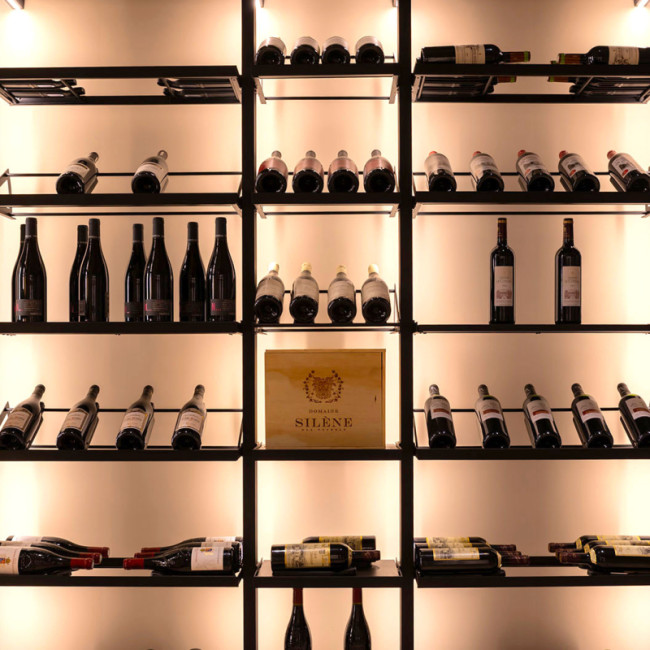 Présentoir pour pièce à vin. Structure modulable en métal avec éclairage intégré pour mise en valeur élégante des bouteilles de vin.