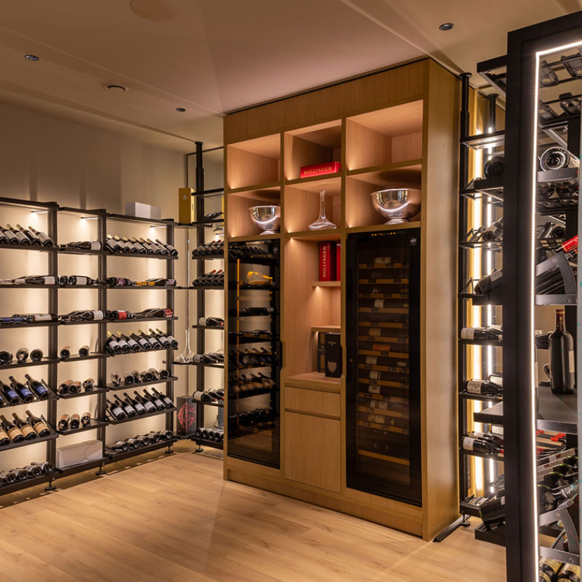 Aménagement de cave à vin pour restaurant avec étagères en métal noir et cave à vin encastrées EuroCave.