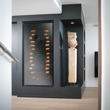 Armoire à vin de vieillissement intégrée dans un meuble sur mesure, installée dans un espace de vie au design contemporain, collection Royale EuroCave, France.