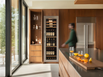 Cave à vin encastrable avec porte technique vitrée et habillage en acier inoxydable, éclairage intégré, installation dans une cuisine moderne, collection Inspiration EuroCave.